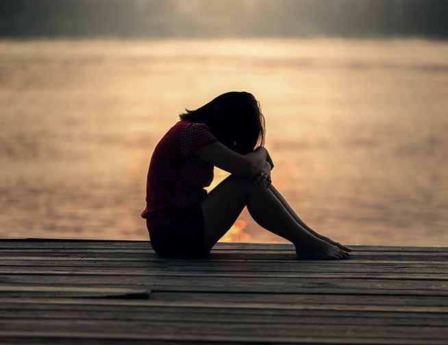 Depression Conceptual representation of Depression - A person sitting alone in a dimly lit room, head bowed.