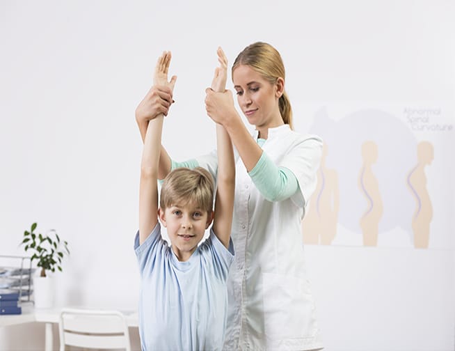 Child exercising with physiotherapist Sports Physical Examination - A young athlete undergoing a comprehensive medical assessment for sports participation.